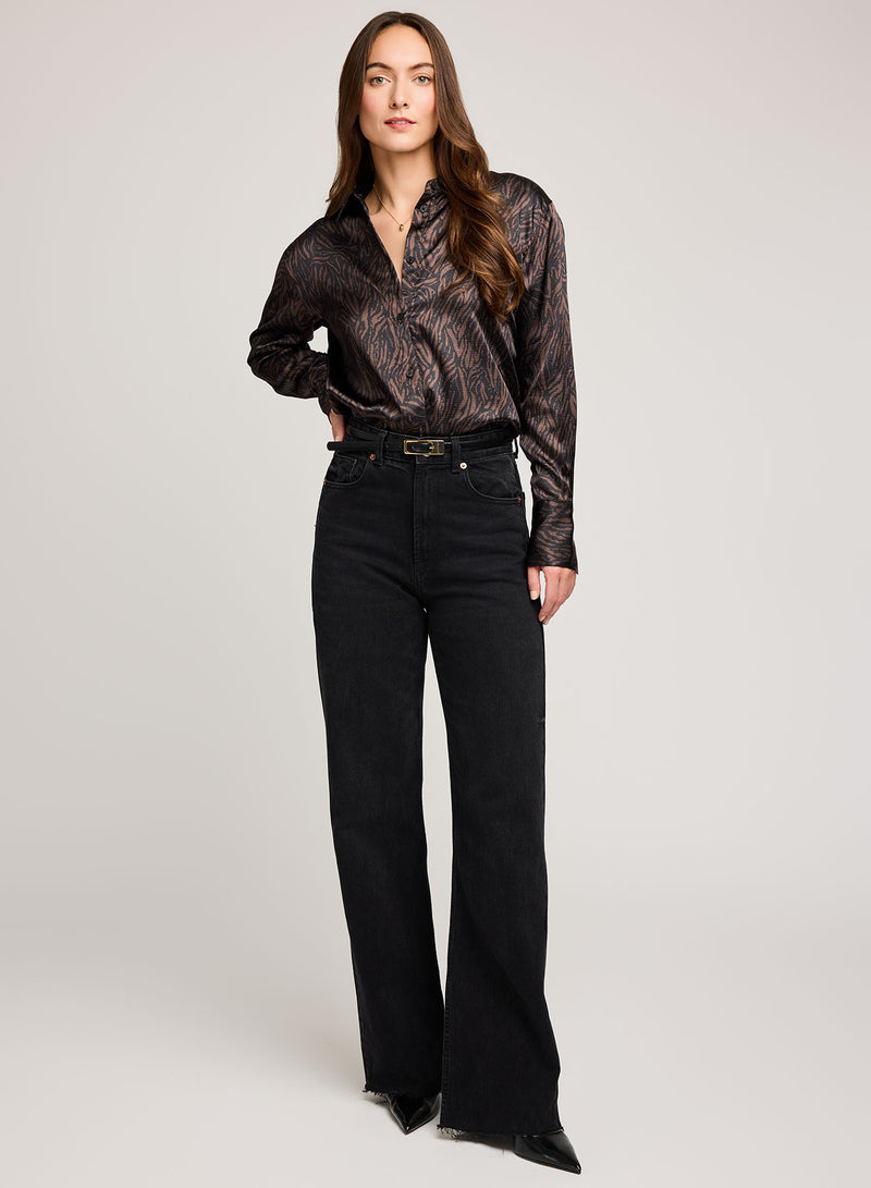 Woman wearing Gentle Fawn's Simone blouse in java print and black pants on a white background