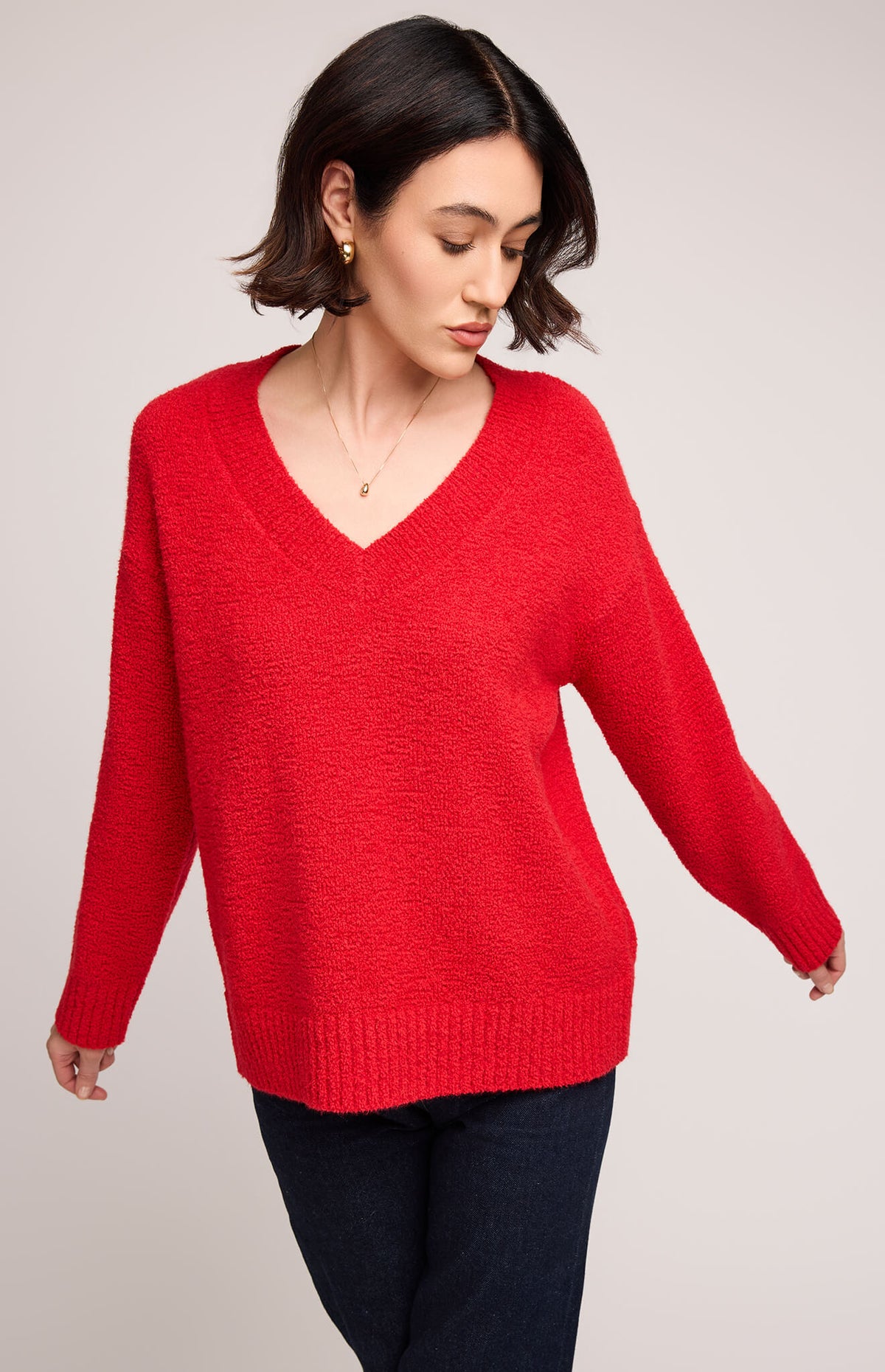 Close-up of Gentle Fawn Tilda Sweater in red showing bouclé yarn texture and v-neckline.