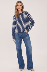 Model wearing the Gentle Fawn Wanda sweater in navy stripe with wide-leg jeans