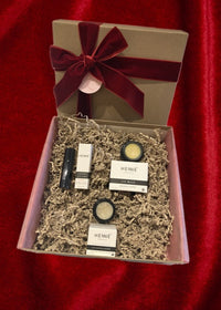 Front view of Lemonberry lip care gift box with Henné Lip Mask, Lip Exfoliator, and Lip Tint, wrapped with burgundy ribbon — Lemonberry Aurora.