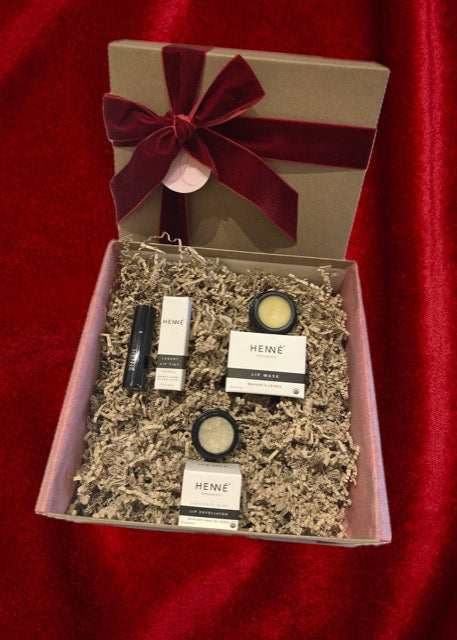 Front view of Lemonberry lip care gift box with Henné Lip Mask, Lip Exfoliator, and Lip Tint, wrapped with burgundy ribbon — Lemonberry Aurora.
