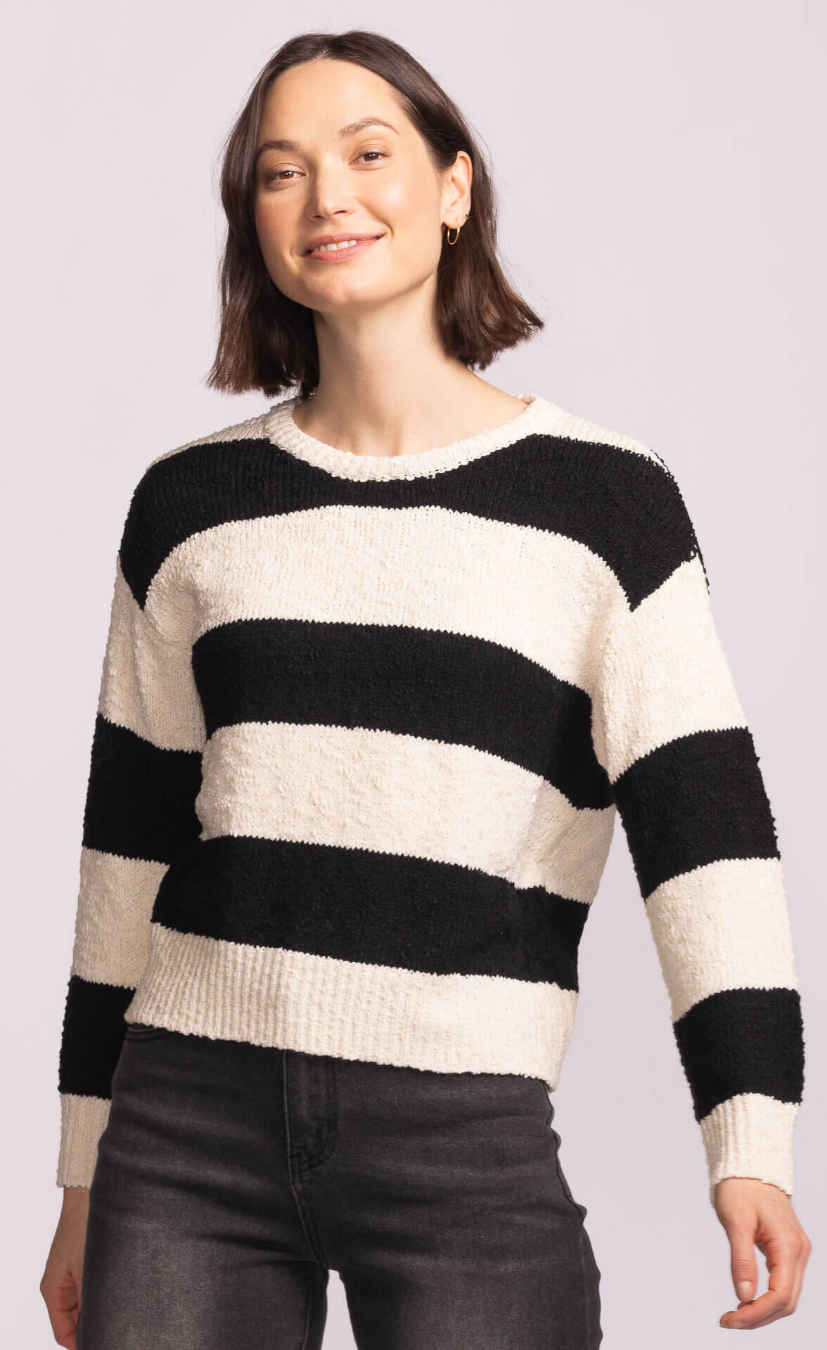 Model smiling in Pink Martini Glynn Sweater, wide horizontal stripes, casual yet polished knit top.