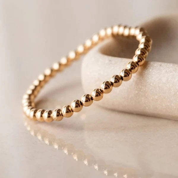 Close-up of the Shiny Soul Gold Intention Bracelet resting on a curved marble surface – available at Lemonberry in Aurora, ON
