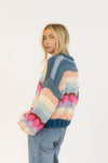 Back view of oversized multicolour Lyla + Luxe sweater on model with light denim