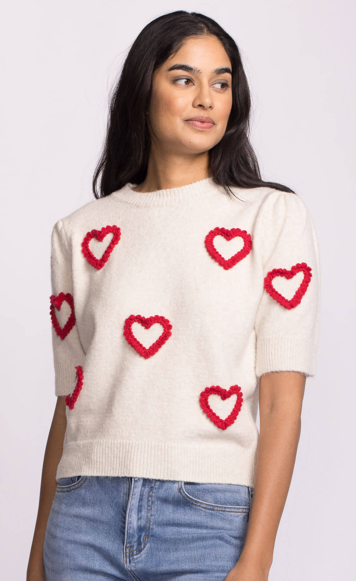 Front view of ivory sweater with red heart motifs, short sleeve knit by Pink Martini.