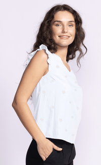 Side view of the Heather Top by Pink Martini, highlighting its flowy fit and embroidered floral details.