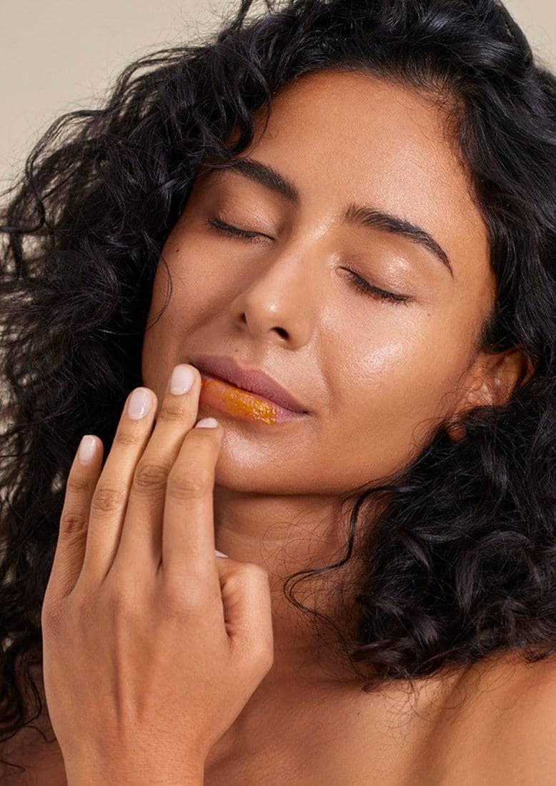 model applying Henné lip mask with fingertip for Lemonberry Aurora