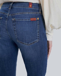 Close-up of back pocket detail on high-waisted skinny jeans, showing signature stitching and soft stretch denim.
