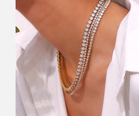 Hoopla gold tennis necklace layered with chunky gold chain on model Lemonberry Aurora