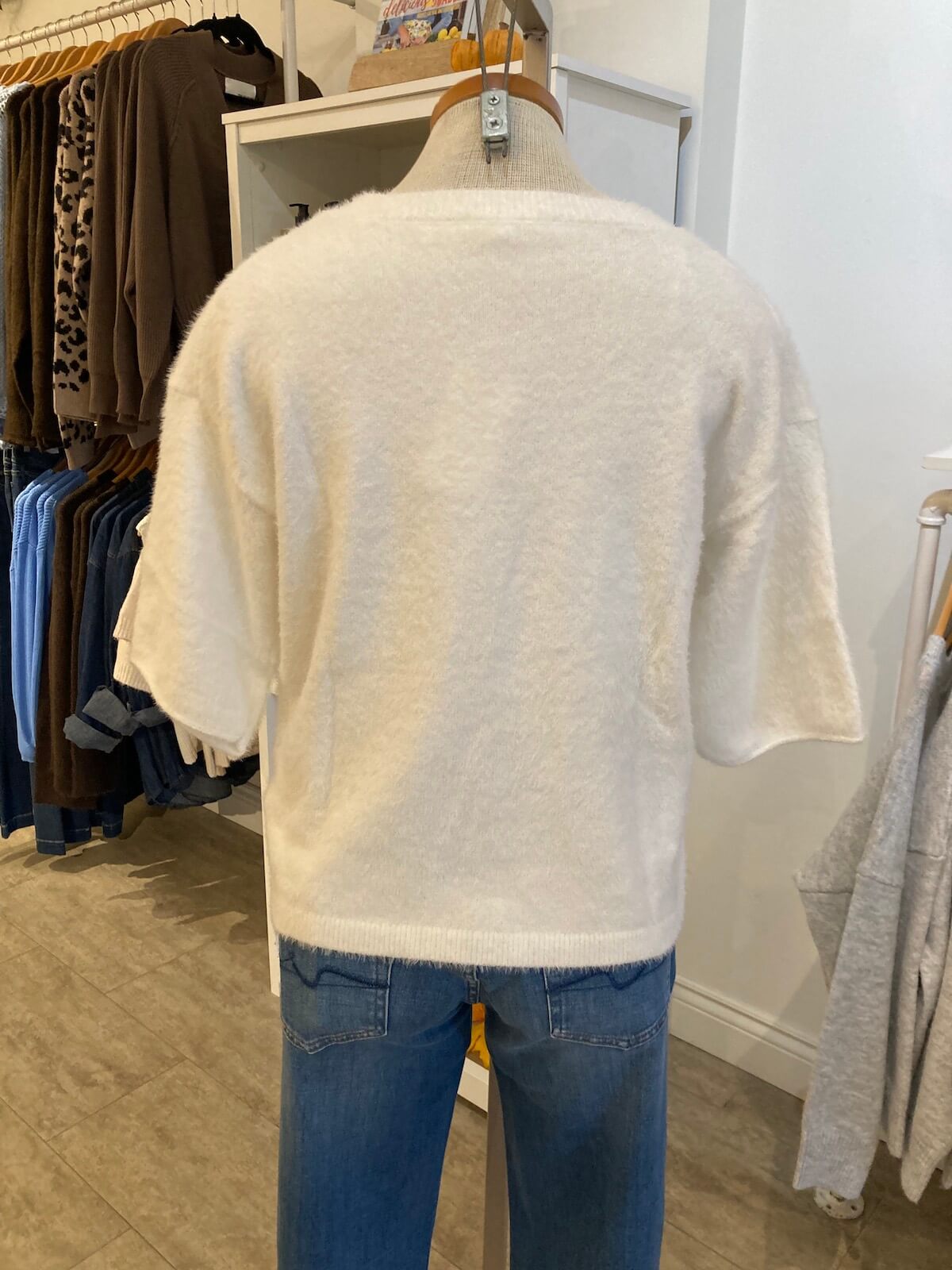 Melissa Nepton Jenna Sweater in Taupe, shown from back on mannequin in boutique, with shelf and sweaters in background