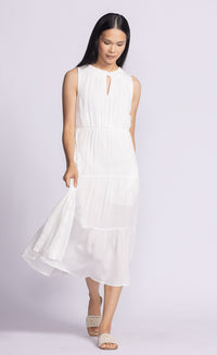 Model wearing the Jennifer Dress by Pink Martini, a tiered flowy midi dress with an elastic waistband, standing in a relaxed pose.