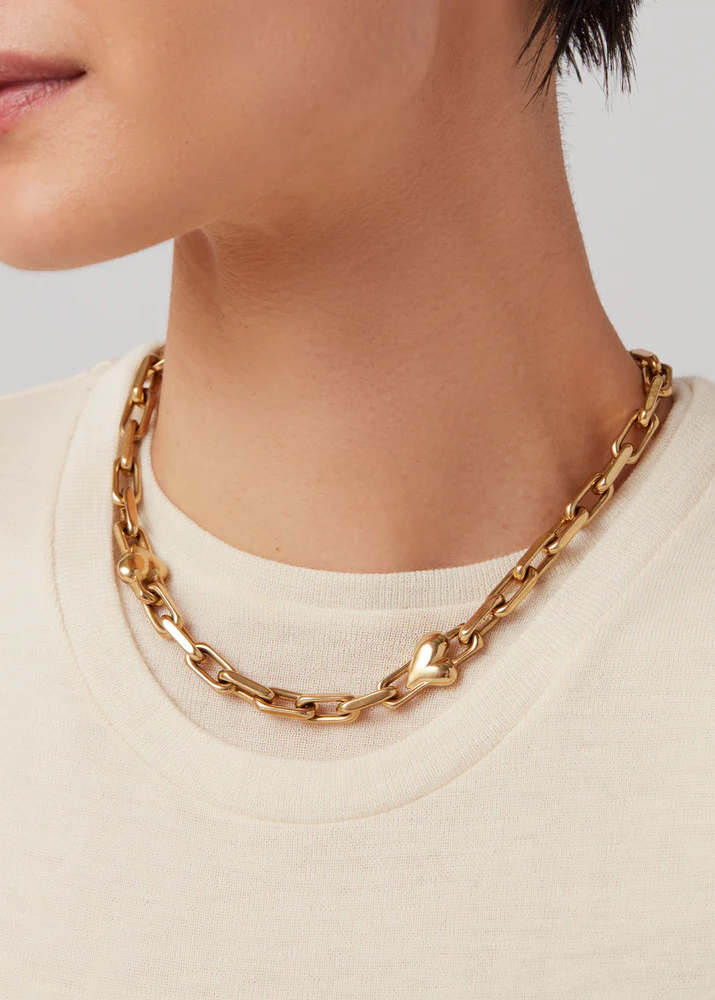 Model wearing Jenny Bird Art Heart Chain Necklace in high-polish gold with crewneck top