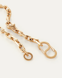 Gold chain bracelet on a light gray background