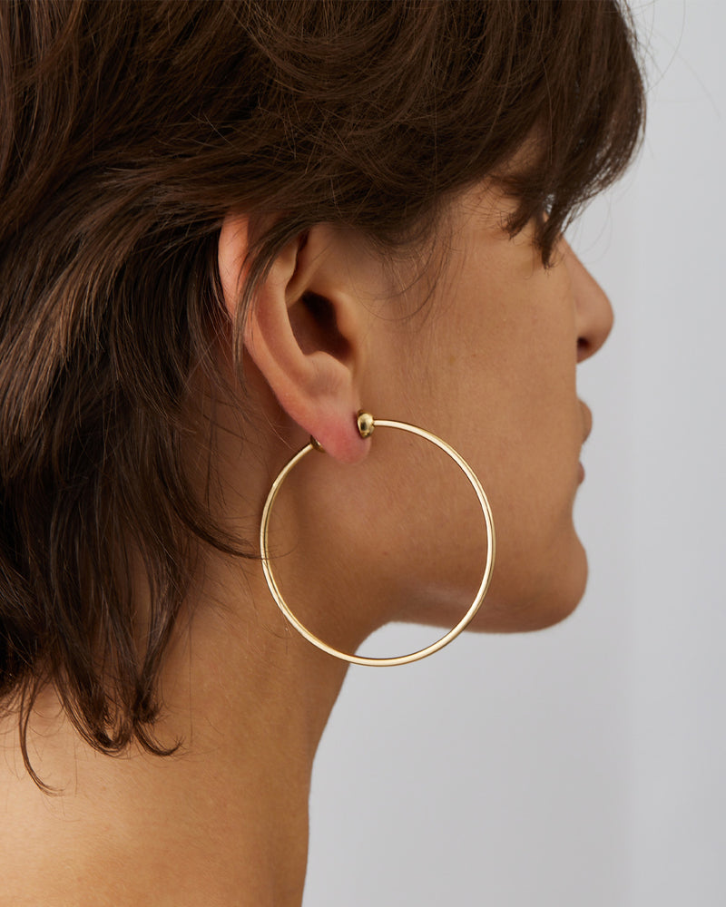 Jenny Bird Icon Hoops Medium gold worn on ear, polished gold hoop earrings with clean silhouette