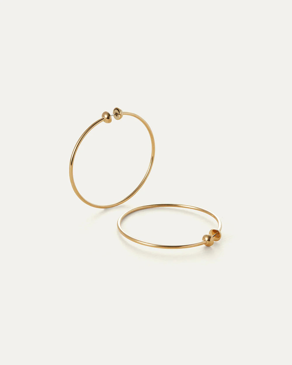 Gold hoop earrings on a light beige background