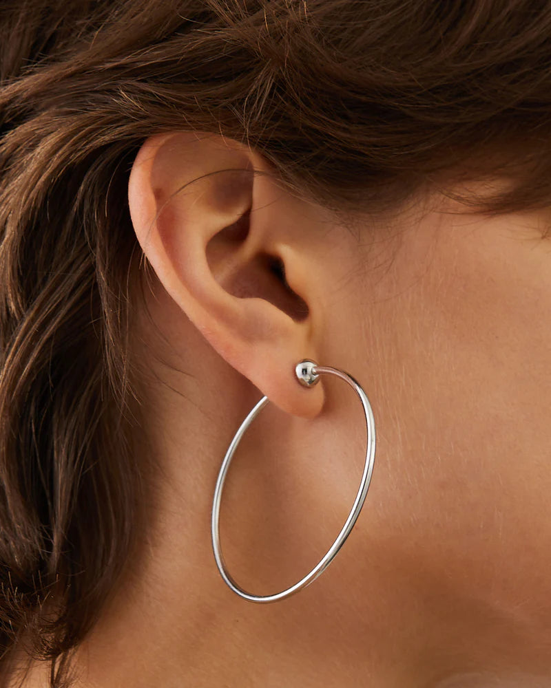Jenny Bird Icon Hoops Medium silver worn on ear, classic medium-size polished hoop earrings