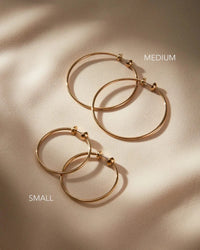 Jenny Bird Icon Hoops Small and Medium side by side on neutral fabric, Lemonberry Aurora — size comparison flatlay.