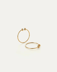 Gold hoop earrings on a light beige background
