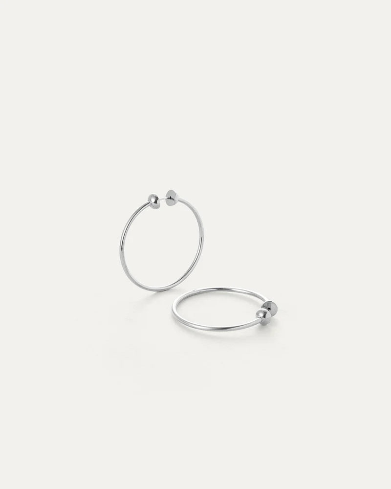 Angled view of Jenny Bird Icon Hoops Small silver with lightweight hollow design