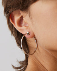 Small silver Jenny Bird Icon hoop earrings worn on ear, minimalist everyday hoops from Lemonberry Aurora
