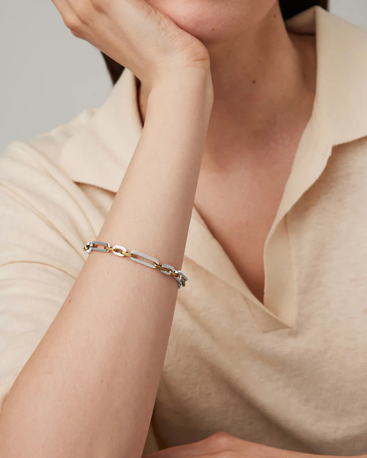 Model wearing the Jenny Bird Mercer Bracelet featuring mixed silver and gold chain links.