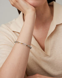Model wearing the Jenny Bird Mercer Bracelet featuring mixed silver and gold chain links.