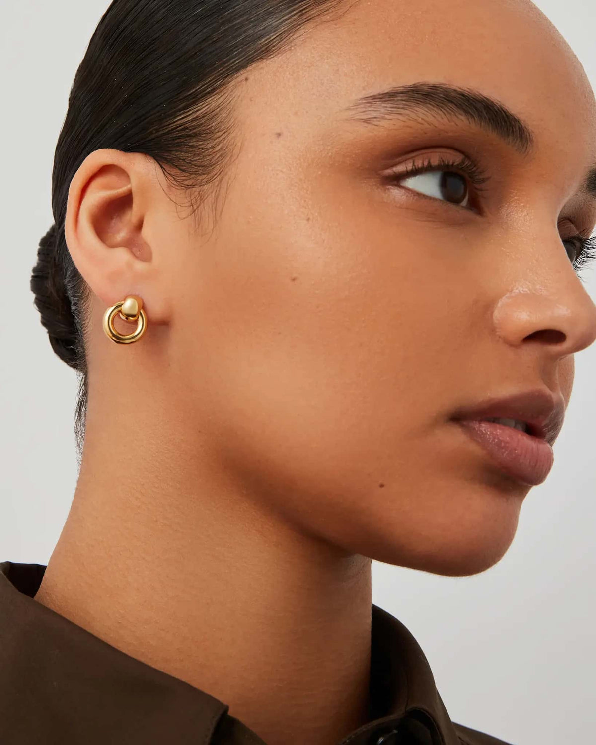 Model wearing Jenny Bird Mini Puffy Faye Knocker Earrings in polished gold