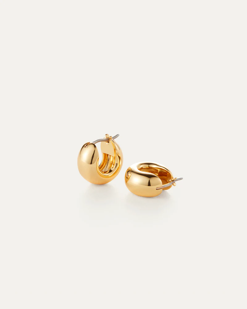 Gold hoop earrings on a light beige background