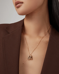 Jenny Bird Gold Sundra Small Necklace with a pendant worn by a person against a neutral background