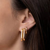 Model wearing Jenny Bird U-Link Earrings in gold, styled for an elegant look with a high polish finish.
