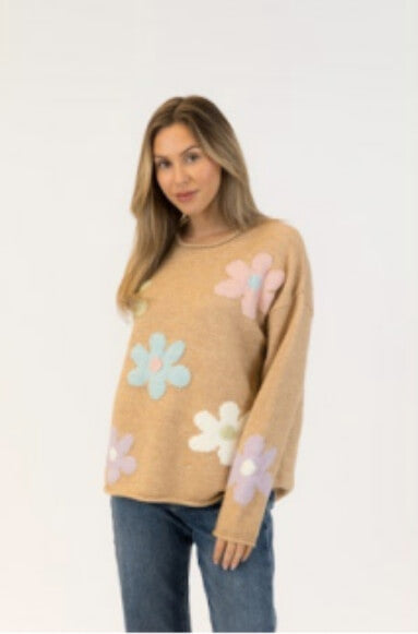 Model in relaxed camel sweater with oversized pastel flower patches on sleeves and body