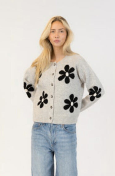 Front view of grey cardigan with bold black-and-white daisy details on arms and torso