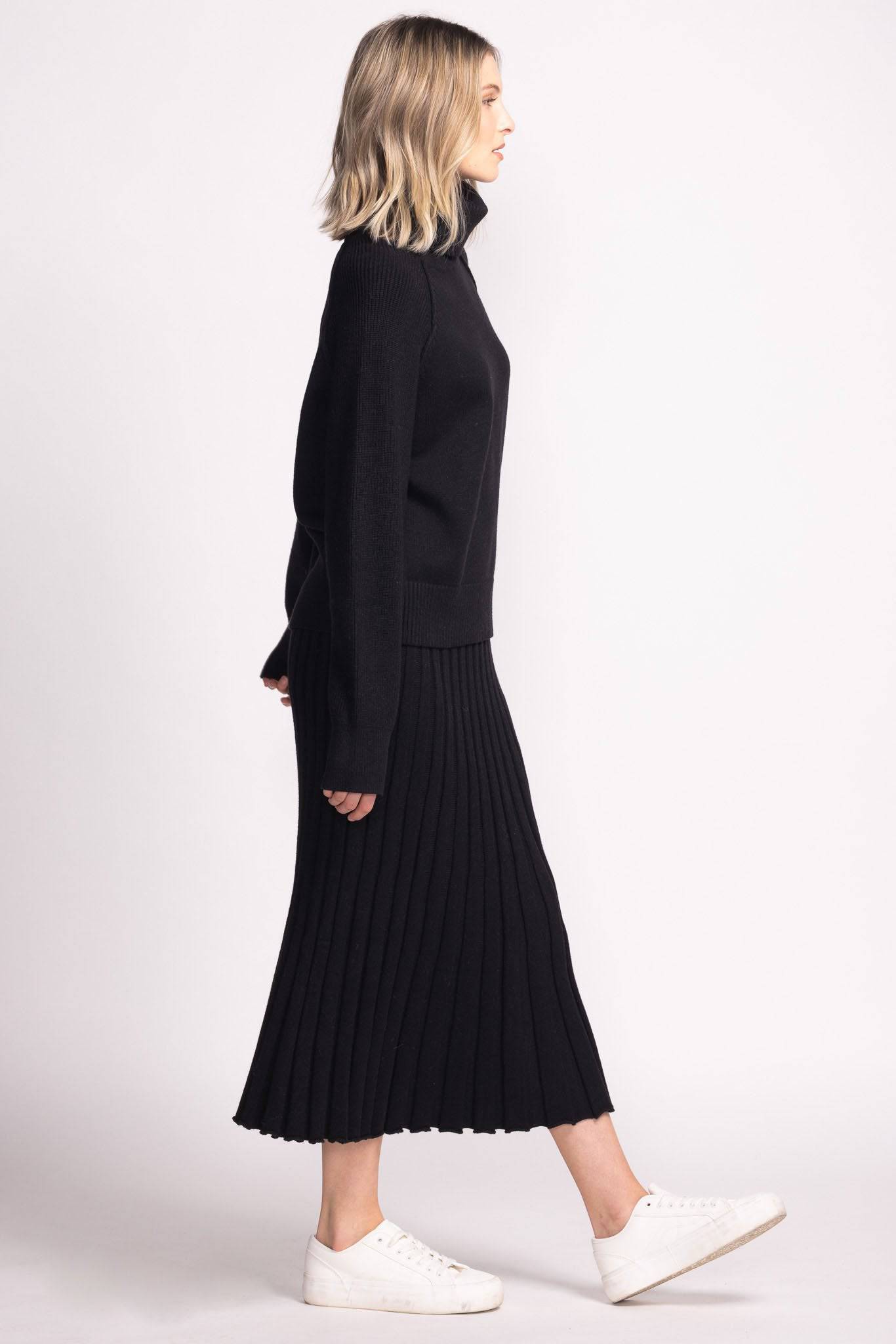 Side profile of Josie Skirt by Pink Martini in black, styled with black turtleneck sweater