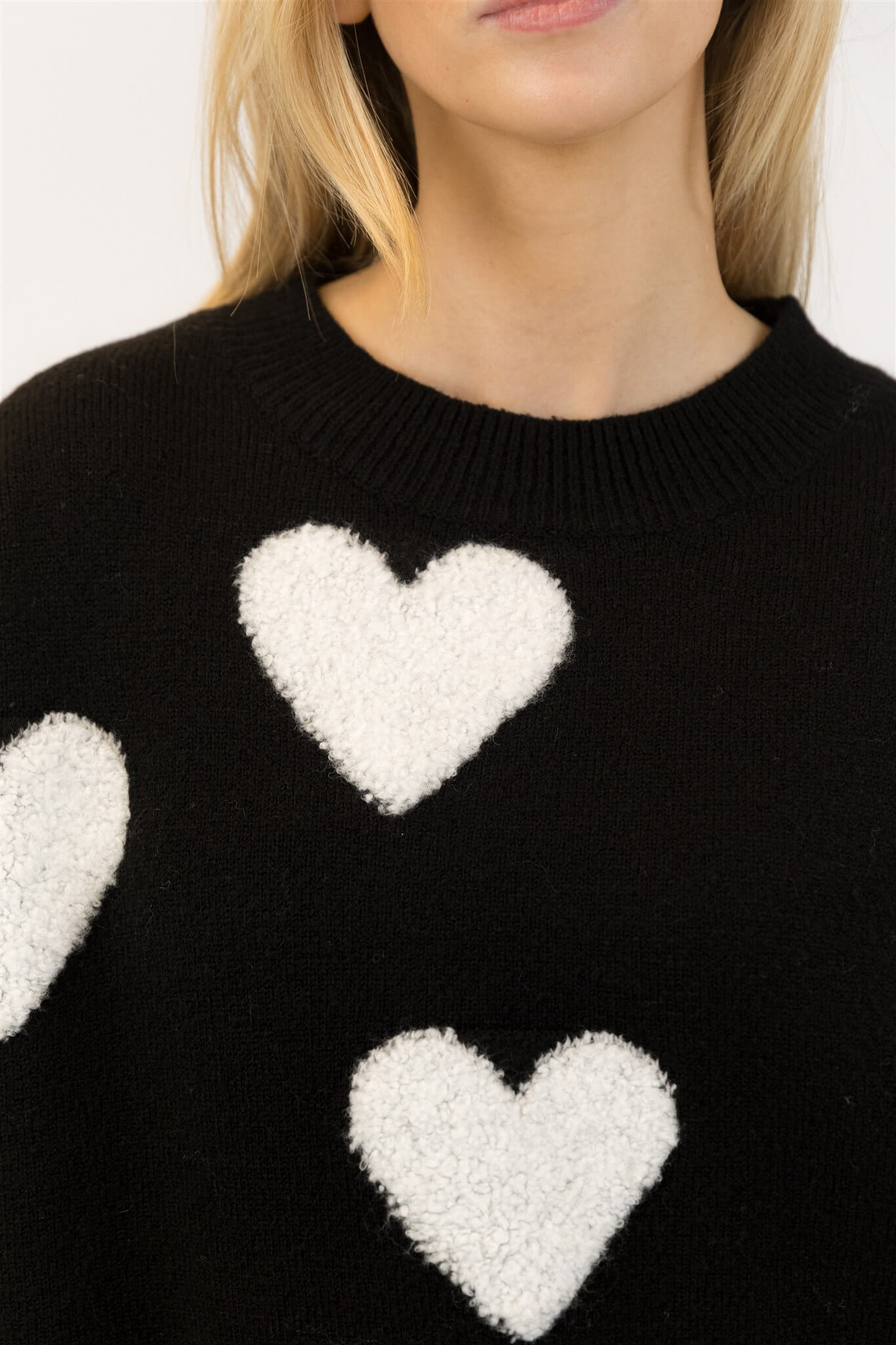 Close-up of Lyla & Luxe Ajax Sherpa Sweater soft sherpa heart detail on black knit