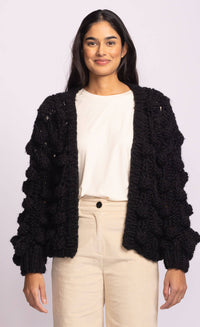 Side view of Raya Sweater by Pink Martini in black, showcasing bubble sleeve detail and relaxed chunky knit – shop Lemonberry Aurora or online.