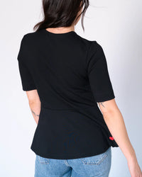 Back view of black Preloved Lisa Peplum Top with signature upcycled red heart patch
