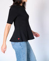 Side view showing flared hem of black Preloved Lisa Peplum Top, red heart detail visible