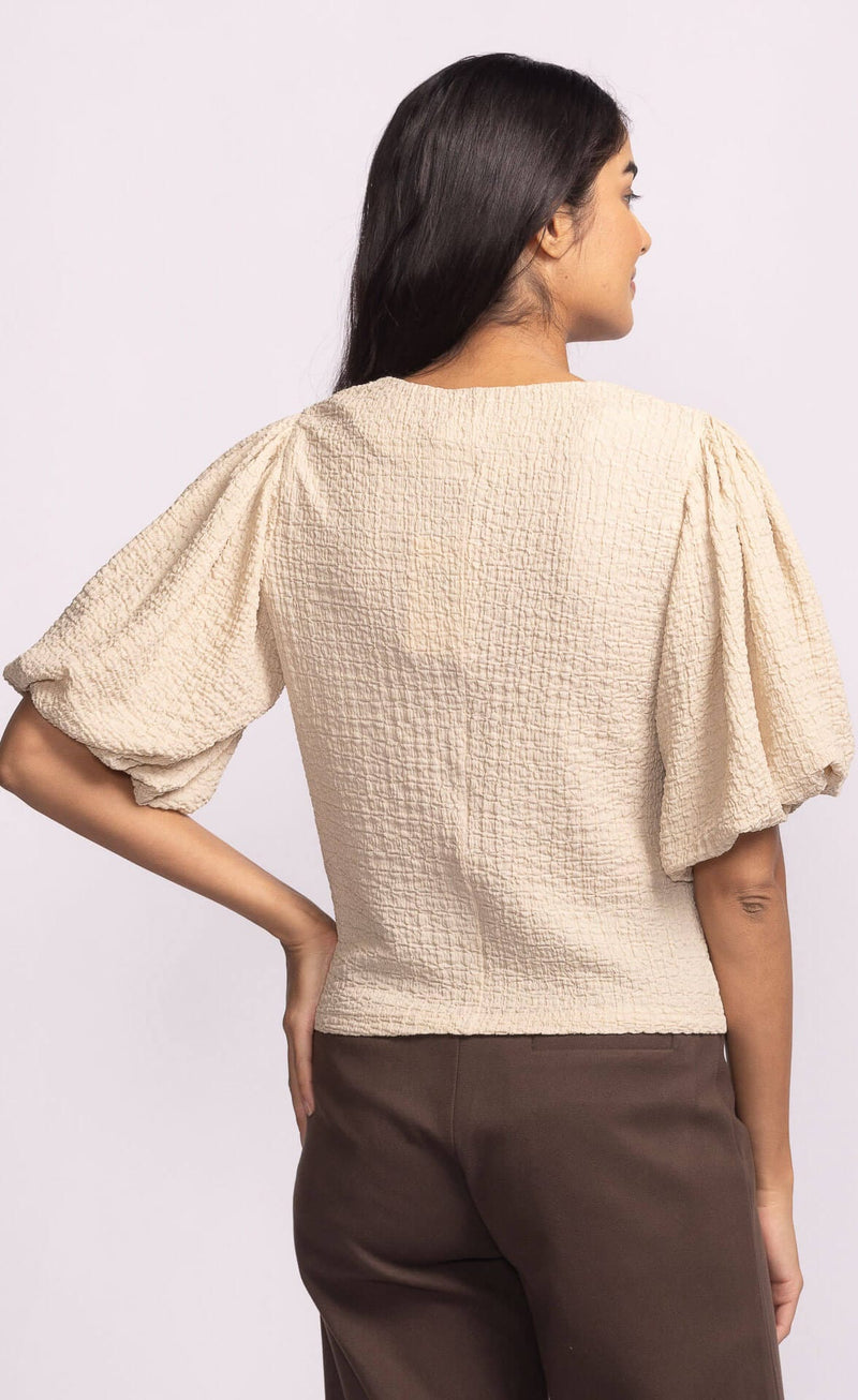 Back view of Pink Martini Lita Top beige textured puff sleeve.