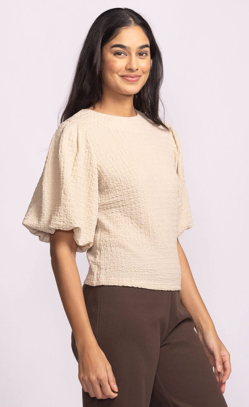 Side angle of Pink Martini Lita Top beige puff sleeve blouse.