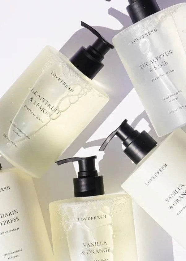 A collection of Lovefresh Everyday Wash bottles in various scents, elegantly arranged to showcase their sleek packaging and natural skincare benefits.