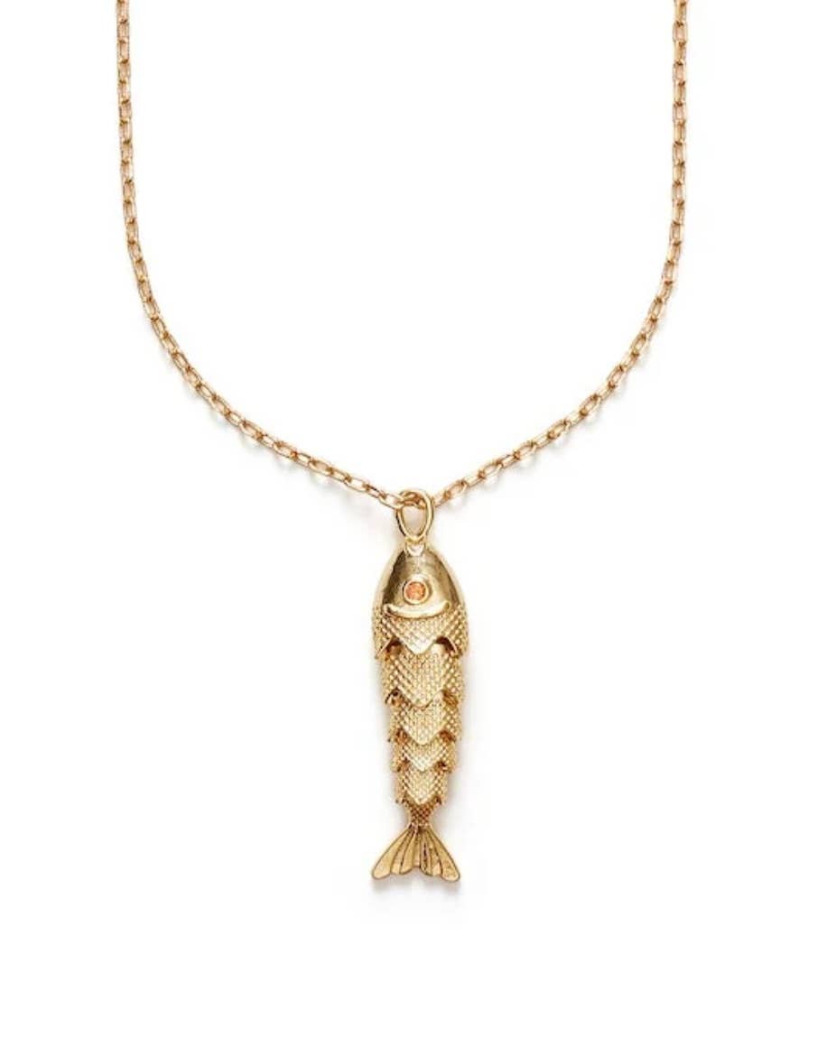 Gold fish-shaped pendant on a chain against a white background