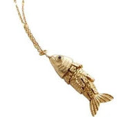 Gold fish-shaped pendant on a chain against a white background