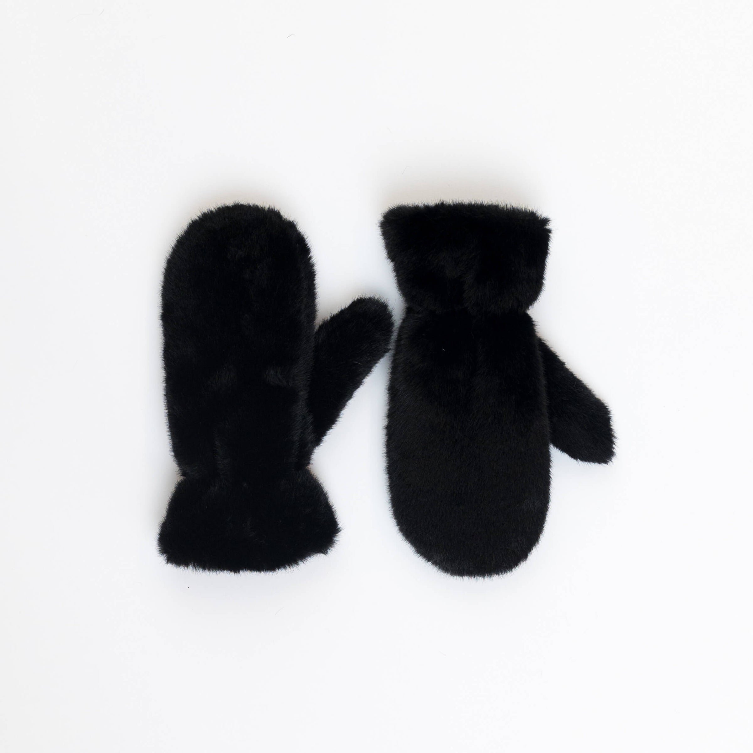 Pair of Lyla & Luxe Luxe Mittens in black faux fur on white background, photographed at Lemonberry in Barrie.