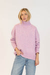 Woman wearing Lyla & Luxe Aggie turtleneck sweater in pink mix, front view with relaxed jeans