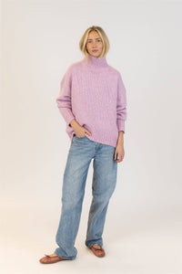 Side view of Lyla & Luxe Aggie pink mix turtleneck sweater paired with denim