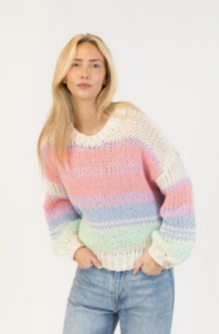 Model wearing Lyla + Luxe Lindy pullover in pastel rainbow stripes with relaxed fit and ribbed trim