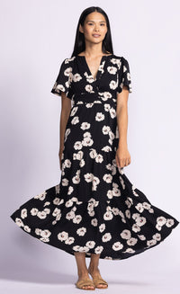 Model wearing the Margaret dress by Pink Martini from Lemonberry in Aurora Ontario, pairing it with brown sandals and performing a slight twirl displaying the skirts bell flair.