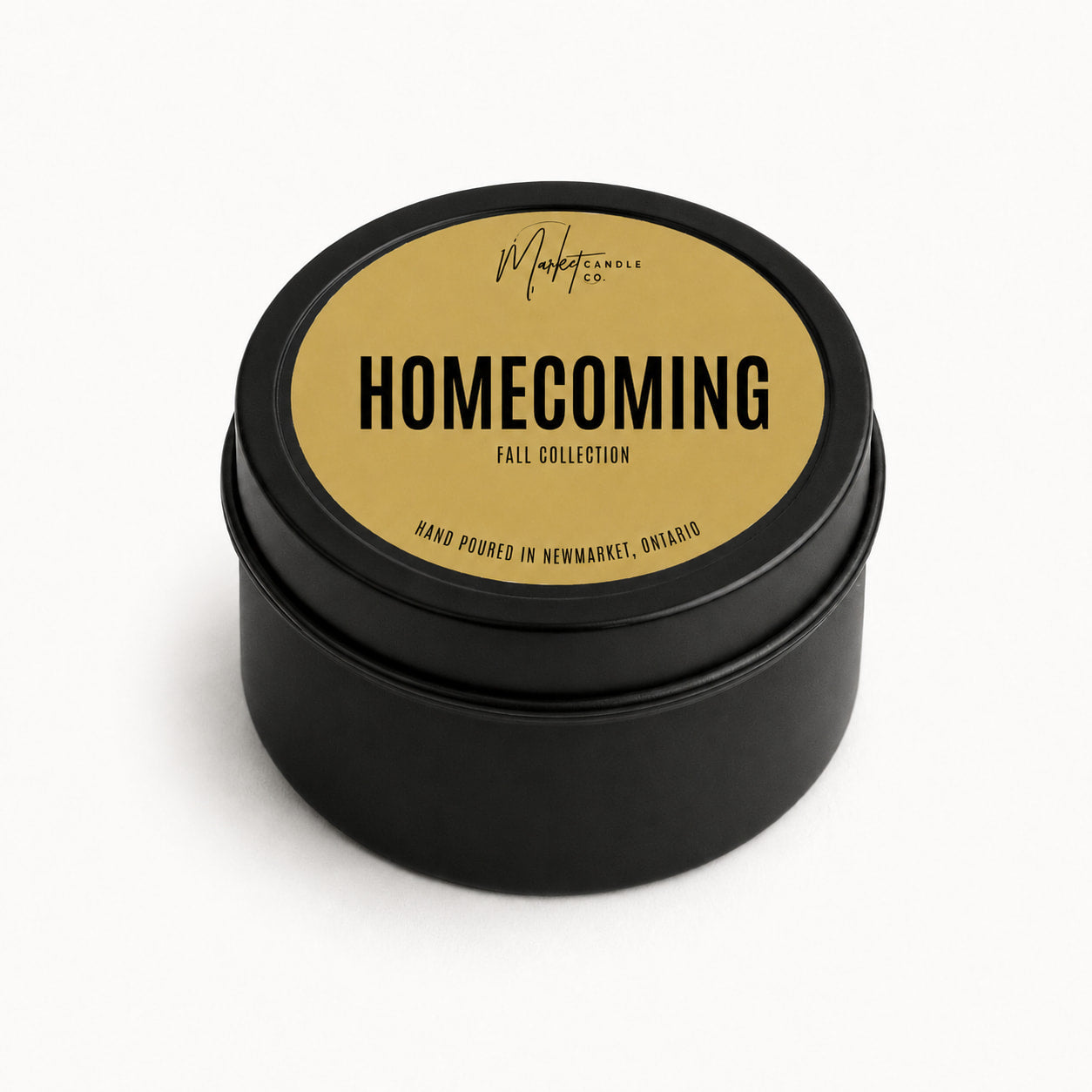 Market Candle Company Homecoming mini soy candle in a black tin with a gold label