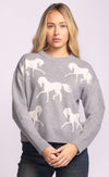 Model wearing the Meadow Sweater in grey with white horse motif, styled with dark denim.