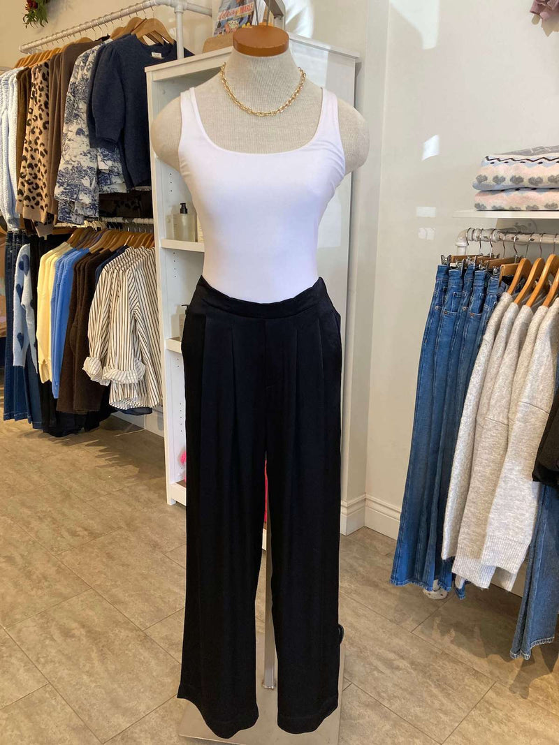 Wide-leg black Eileen Pant by Melissa Nepton styled with white tank, boutique display in background